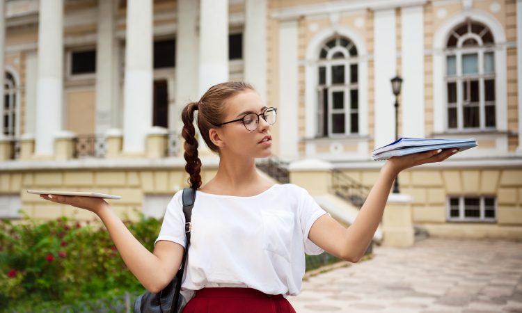 Na slici je studentkinja koja nosi tablet i sveske u dvije različite ruke