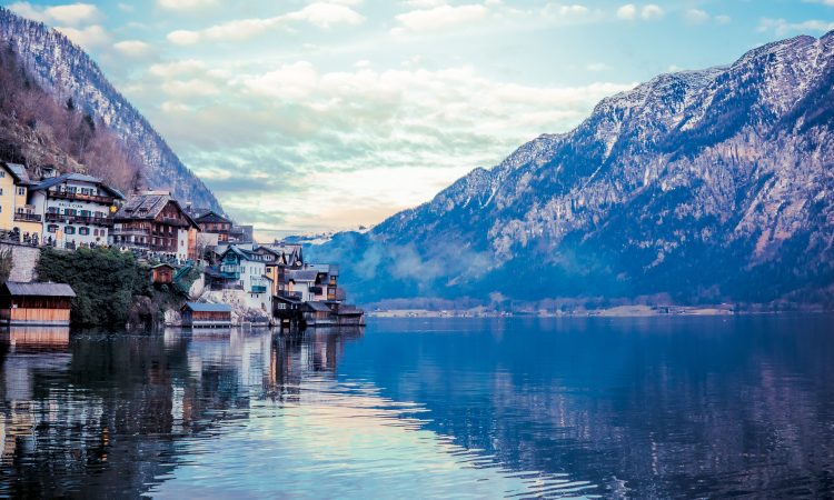 A beautiful scenery of buildings by the lake surrounded by mountains in Hallstatt, Austria