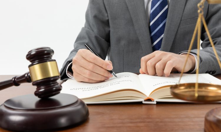 closeup-shot-person-writing-book-with-gavel-table.jpg