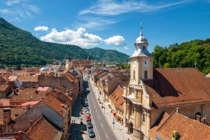 Aerial drone view of Brasov, Romania. Old city centre with Council Square in the distance, buildings, people and greenery
