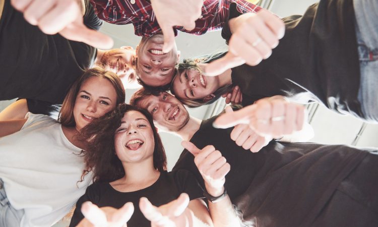Happy group of friends with their hands together in the middle