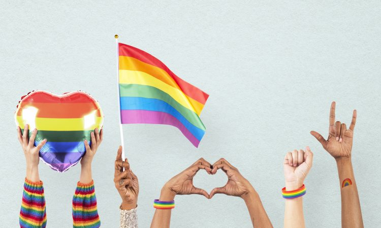 LGBTQ+ pride celebration with hand and crowd cheering