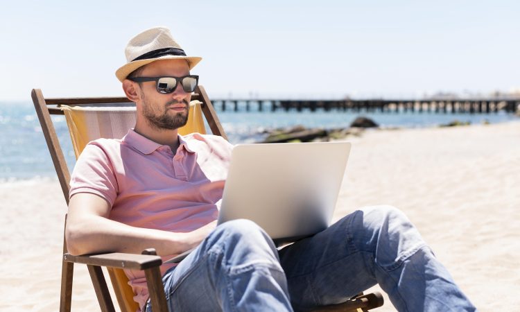 man-working-laptop-beach-chair