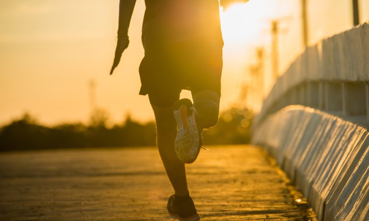 silhouette of a young fitness man running on sunrise