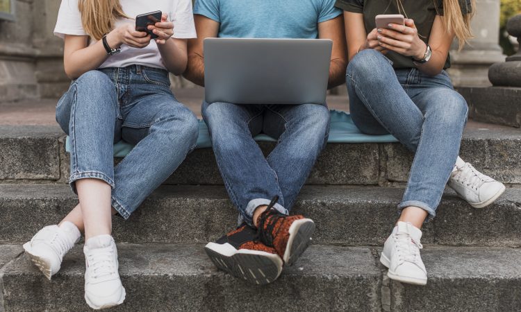 teens-sitting-stairs-working-phones-laptop
