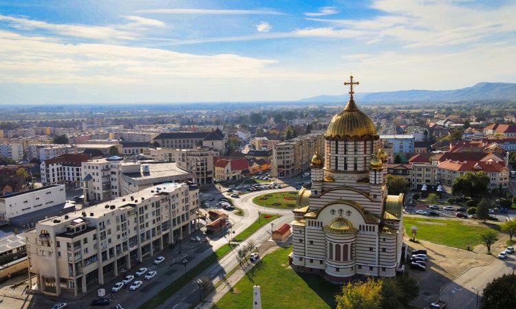Aerial drone view of the Fagaras, Romania. Church of the Saint John the Baptist, buildings, roads with cars, greenery