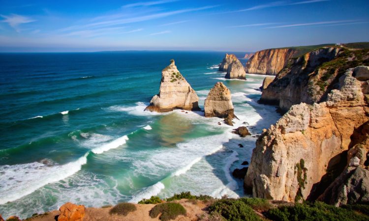 Rugged cliffs rising from a turquoise sea.